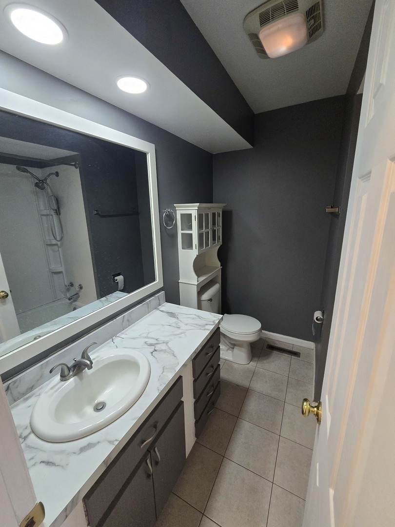 905 Hickory Road Woodstock, IL 60098 - Photo 18 of 32 a bathroom with a sink double vanity and toilet