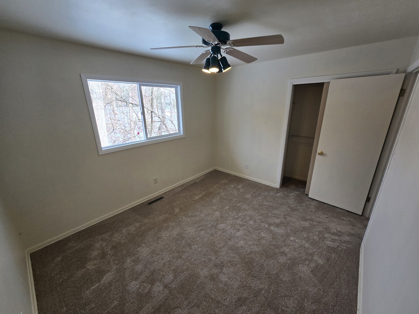 905 Hickory Road Woodstock, IL 60098 - Photo 22 of 32 an empty room with windows and fan