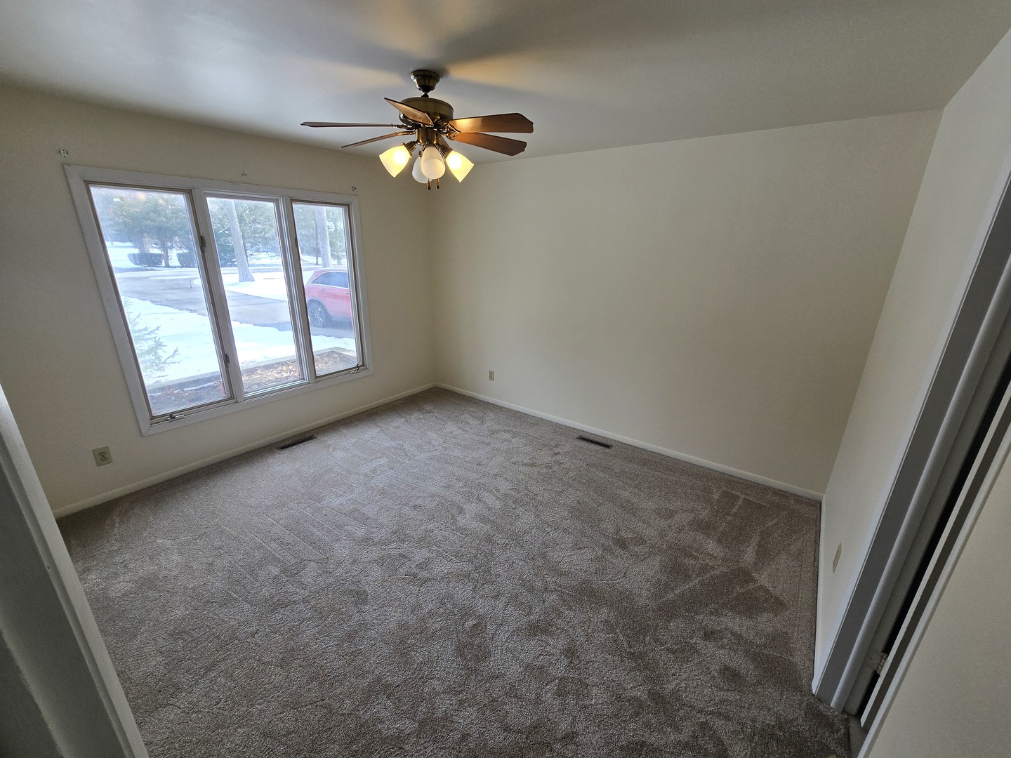 905 Hickory Road Woodstock, IL 60098 - Photo 25 of 32 an empty room with windows and chandelier fan