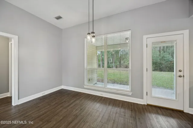 a view of wooden floor and windows in a room