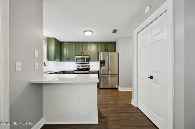 a kitchen with stainless steel appliances a refrigerator and a stove top oven