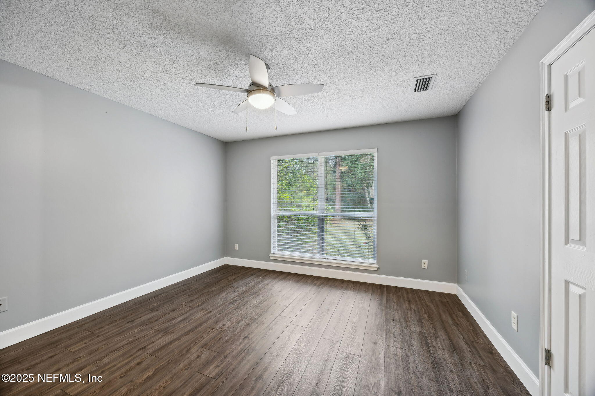 13193 Caldwell Road Jacksonville, FL 32226 - Photo 19 of 50 an empty room with wooden floor and windows