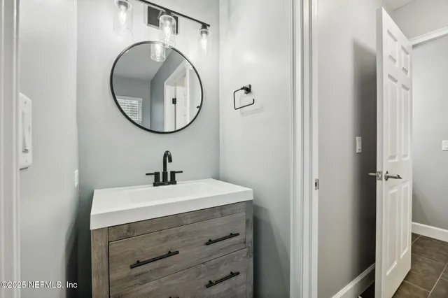 a bathroom with a sink a mirror and a light fixture