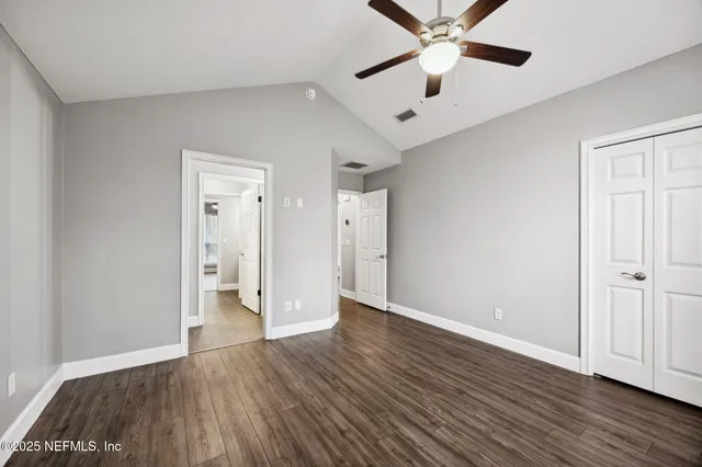 an empty room with wooden floor a ceiling fan and closet