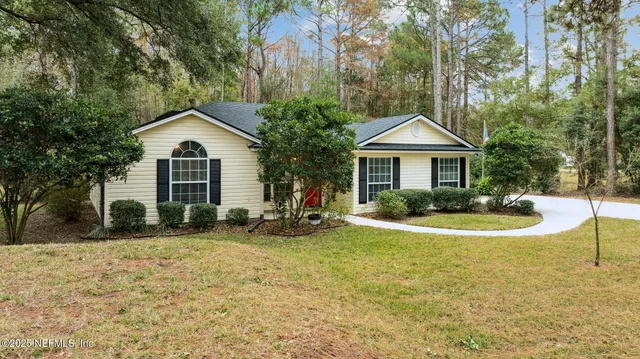 a front view of a house with a yard and trees