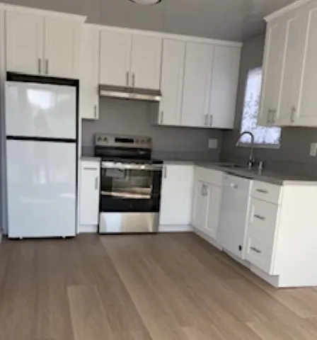 a kitchen with granite countertop white cabinets and stainless steel appliances