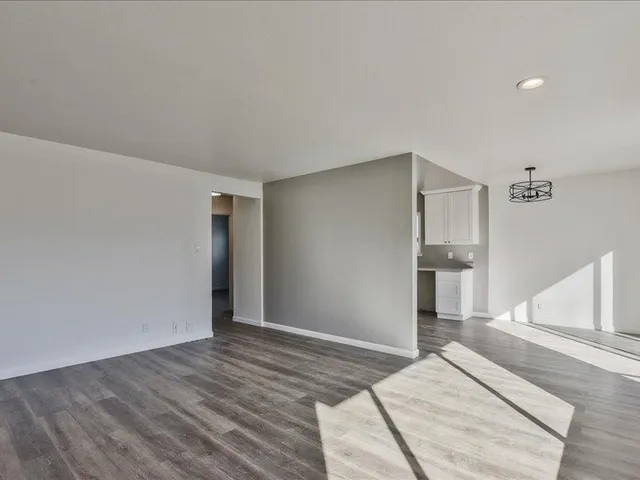 a view of a bedroom with wooden floor and hallway