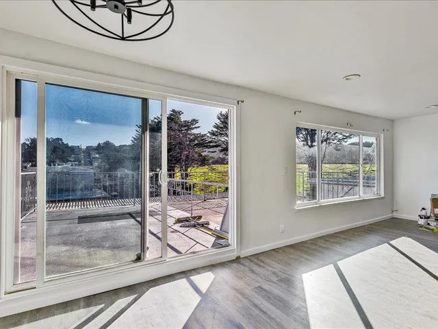 a view of a livingroom with wooden floor and a floor to ceiling window