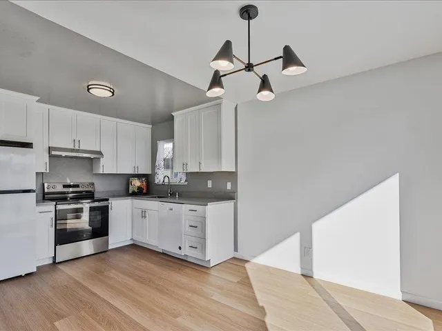 a kitchen with stainless steel appliances granite countertop a sink a stove a refrigerator and cabinets