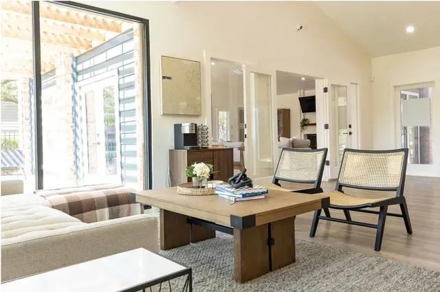 a living room with furniture a large window and a chandelier