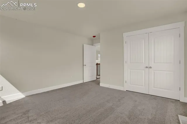 an empty room with a ceiling fan and window