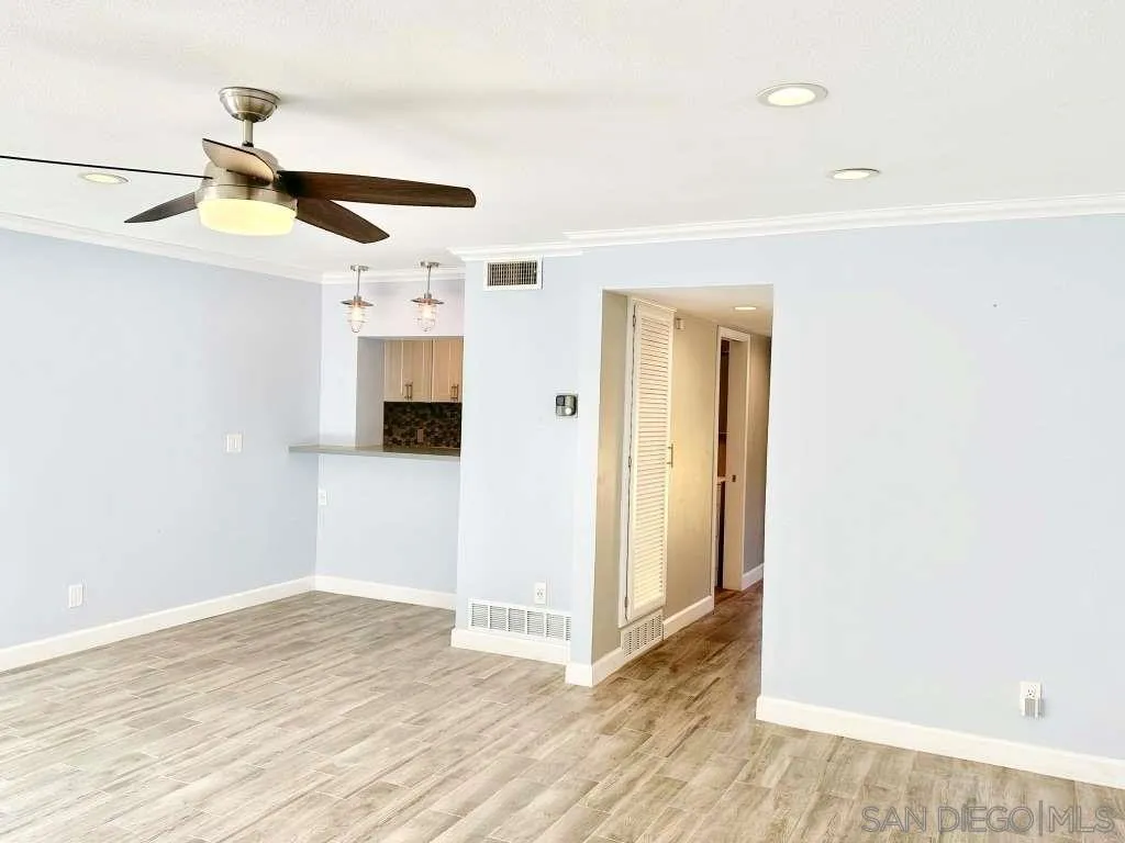 6855 Friars Road, Unit 14 San Diego, CA 92108 - Photo 20 of 31 a view of a livingroom with wooden floor and a ceiling fan