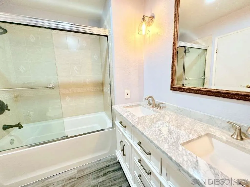 6855 Friars Road, Unit 14 San Diego, CA 92108 - Photo 21 of 31 a bathroom with a granite countertop bathtub shower sink and mirror