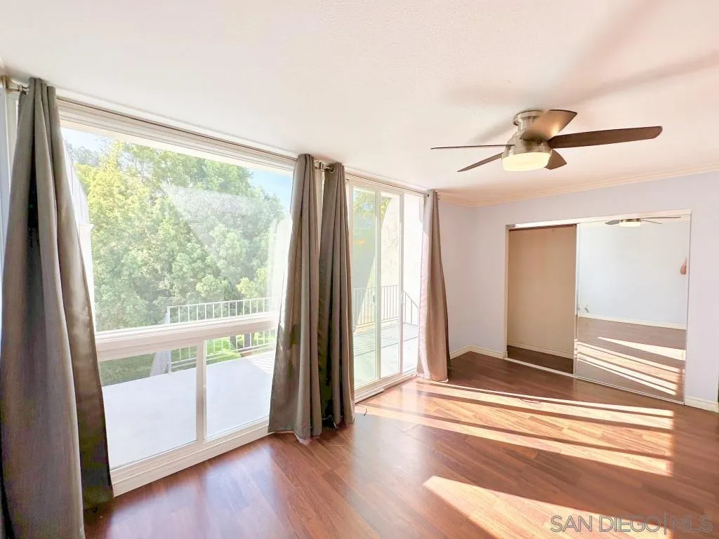 6855 Friars Road, Unit 14 San Diego, CA 92108 - Photo 23 of 31 a view of a bedroom with wooden floor and windows