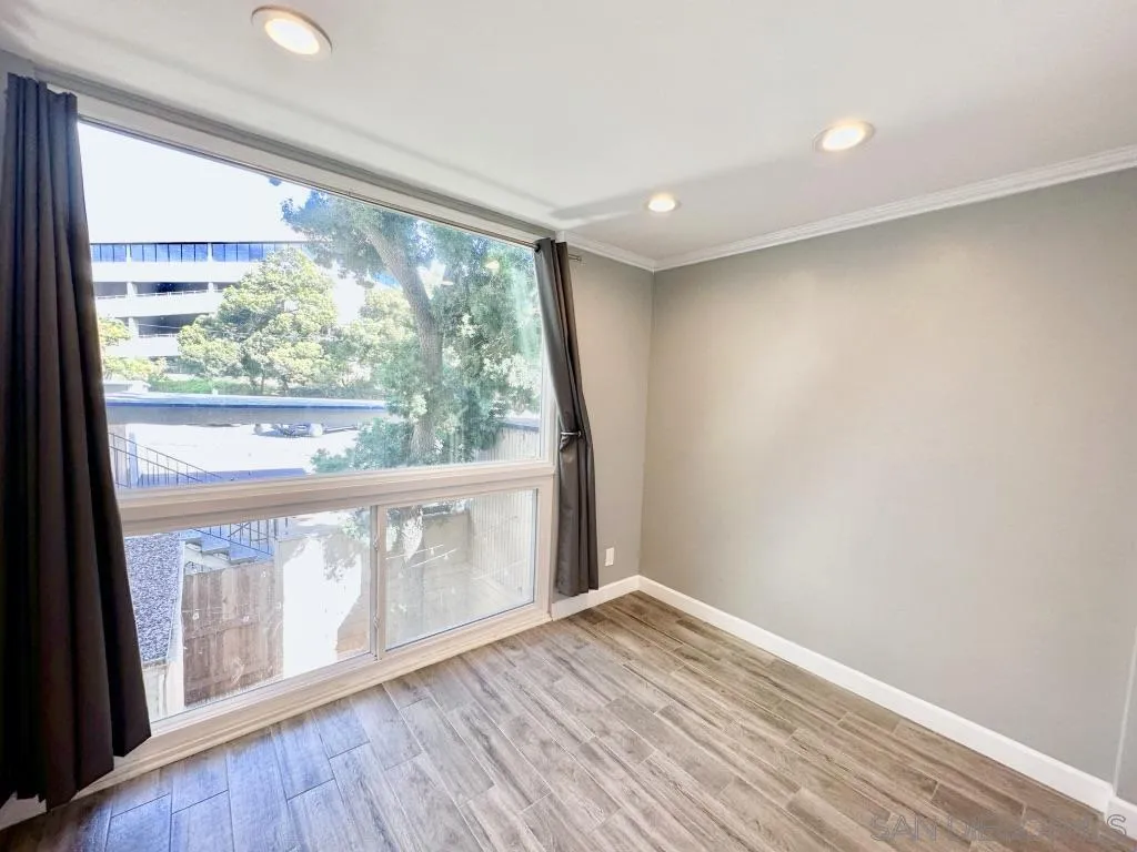 6855 Friars Road, Unit 14 San Diego, CA 92108 - Photo 24 of 31 a view of an empty room with wooden floor and a window