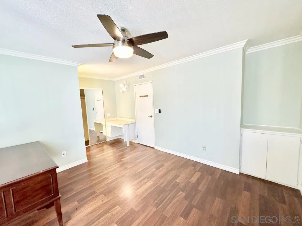 6855 Friars Road, Unit 14 San Diego, CA 92108 - Photo 25 of 31 a view of an empty room with wooden floor and a ceiling fan
