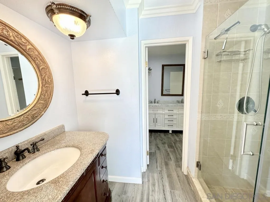 6855 Friars Road, Unit 14 San Diego, CA 92108 - Photo 27 of 31 a bathroom with a granite countertop sink a mirror and a shower