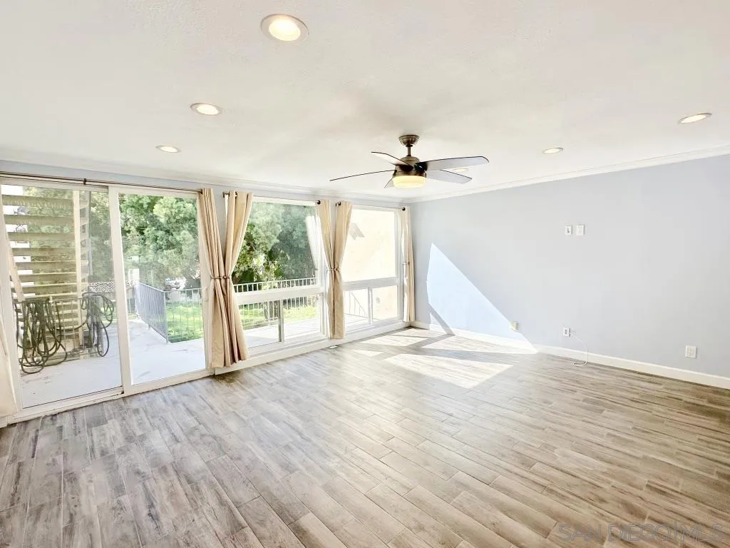 6855 Friars Road, Unit 14 San Diego, CA 92108 - Photo 3 of 31 a view of an empty room with a window and wooden floor