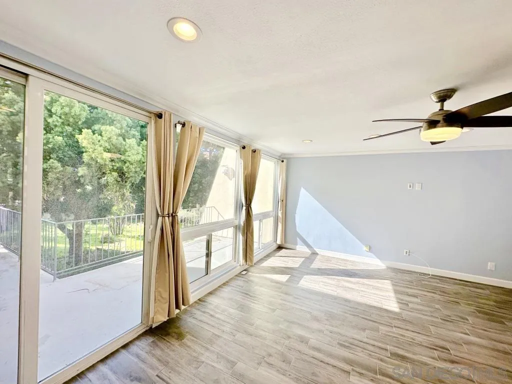 6855 Friars Road, Unit 14 San Diego, CA 92108 - Photo 4 of 31 a view of an empty room with wooden floor and a window