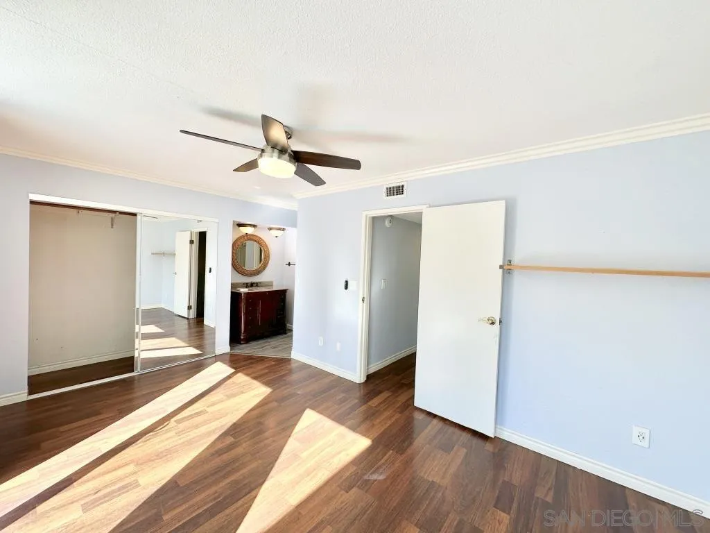 6855 Friars Road, Unit 14 San Diego, CA 92108 - Photo 7 of 31 a view of a livingroom with wooden floor and a ceiling fan