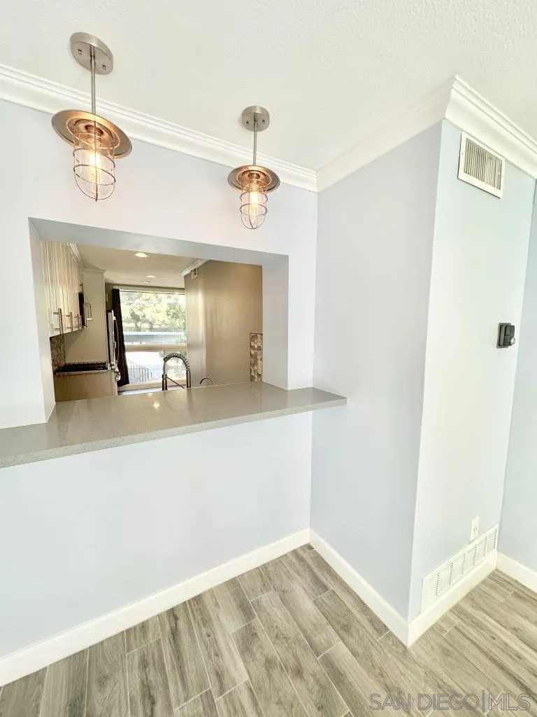 6855 Friars Road, Unit 14 San Diego, CA 92108 - Photo 10 of 31 a view of a hallway with wooden floor and chandelier