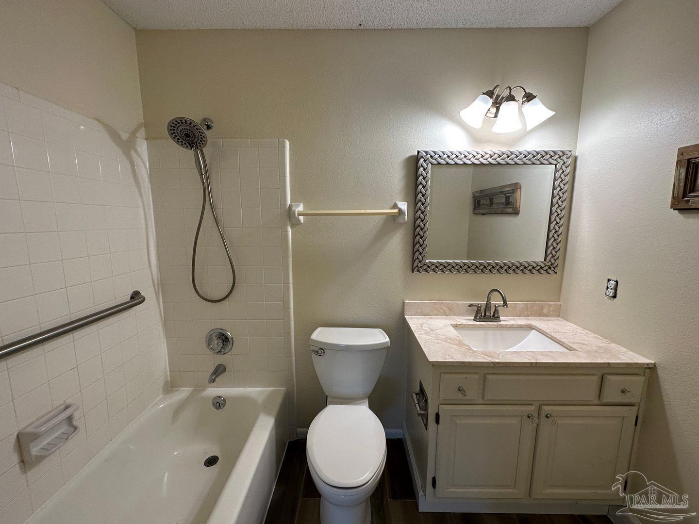 4831 East Olive Road, Unit 4D Pensacola, FL 32514 - Photo 14 of 17 a bathroom with a toilet sink and mirror
