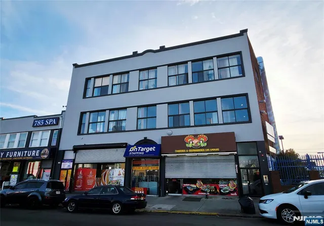a building with glass windows and a car parked