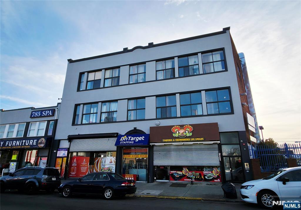 a building with glass windows and a car parked