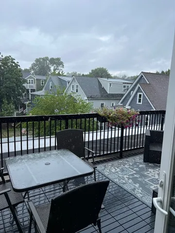 a view of a roof deck with table and chairs with wooden floor