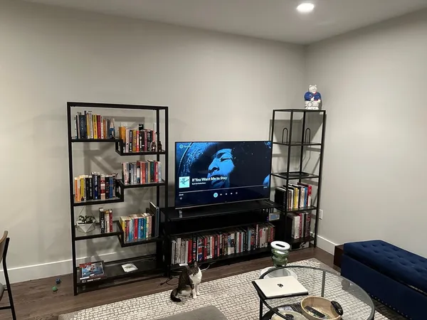 a living room with furniture a bookshelf and a window