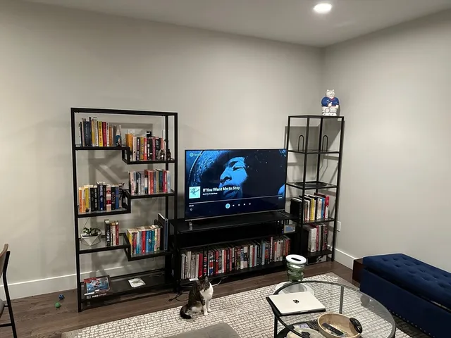 a living room with furniture a bookshelf and a window