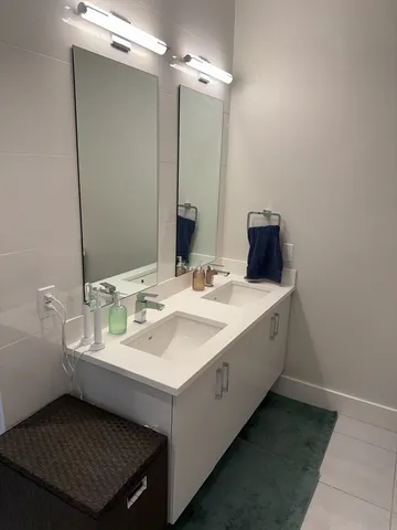 a bathroom with a double vanity sink and a mirror