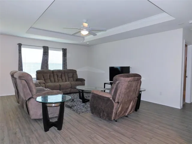 a living room with furniture and a wooden floor
