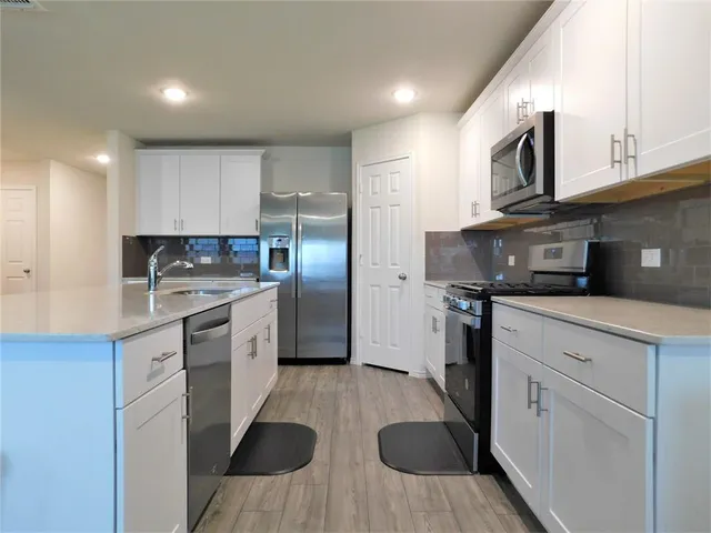 a kitchen with cabinets and stainless steel appliances