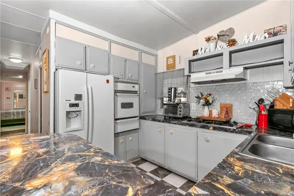 a kitchen with stainless steel appliances granite countertop a refrigerator and a sink
