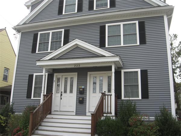 223 Robbins Street, Unit 1 Waltham, MA 02453 - Photo 2 of 12 a front view of a house with a yard