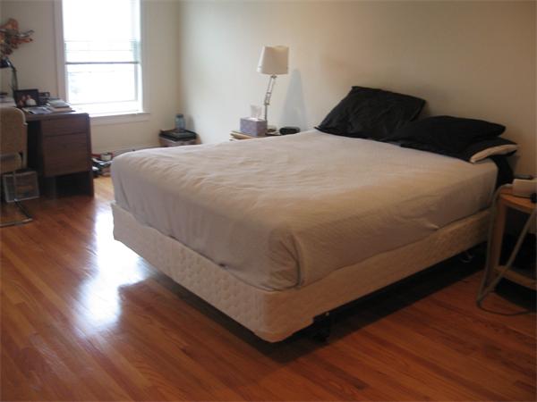 223 Robbins Street, Unit 1 Waltham, MA 02453 - Photo 8 of 12 a bedroom with a bed and wooden floor