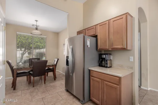 a kitchen with stainless steel appliances granite countertop a table chairs and a refrigerator