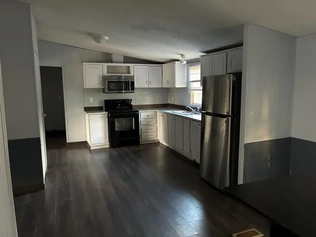 a kitchen with stainless steel appliances a refrigerator and a stove top oven