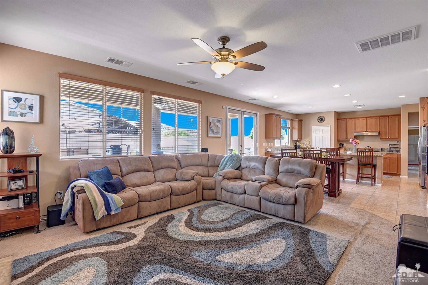 83447 Lone Star Road Indio, CA 92203 - Photo 15 of 47 a living room with furniture a ceiling fan and a large window