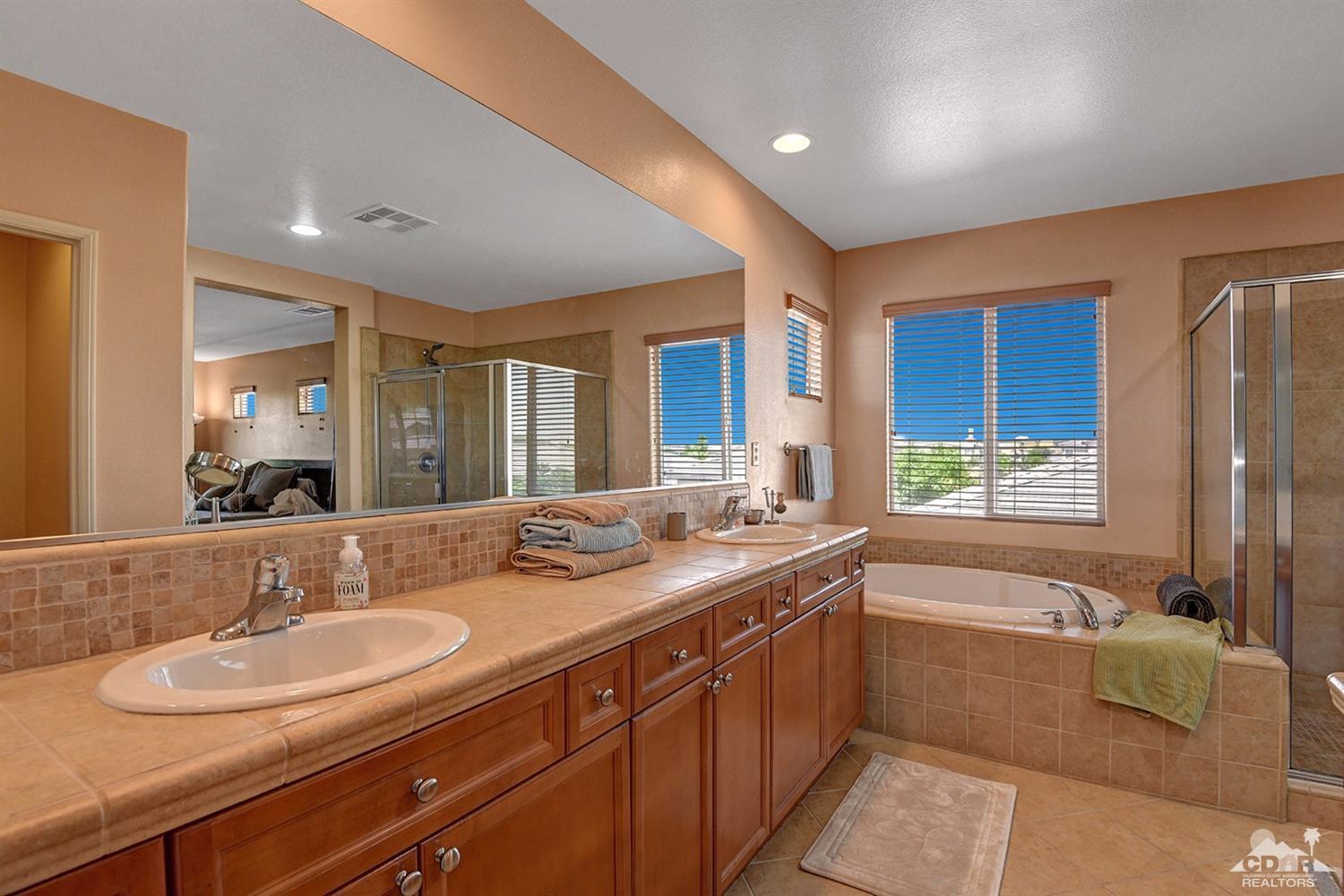 83447 Lone Star Road Indio, CA 92203 - Photo 32 of 47 a bathroom with a granite countertop sink mirror and a bath tub