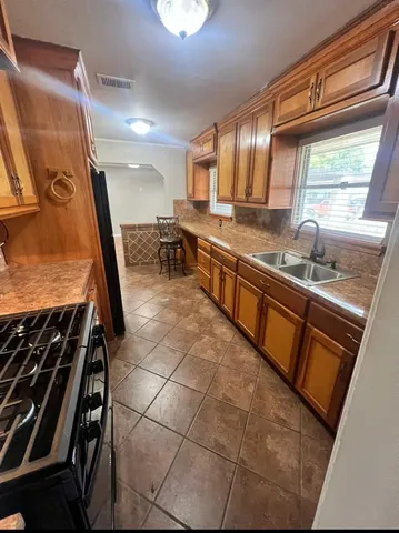 a kitchen with granite countertop a sink a stove and a microwave