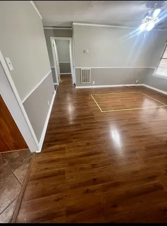 a view of empty room with wooden floor
