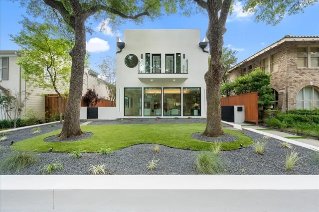 a front view of a house with a yard and tree s