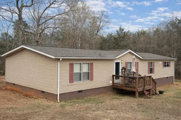 a view of a house with a yard and wooden fence