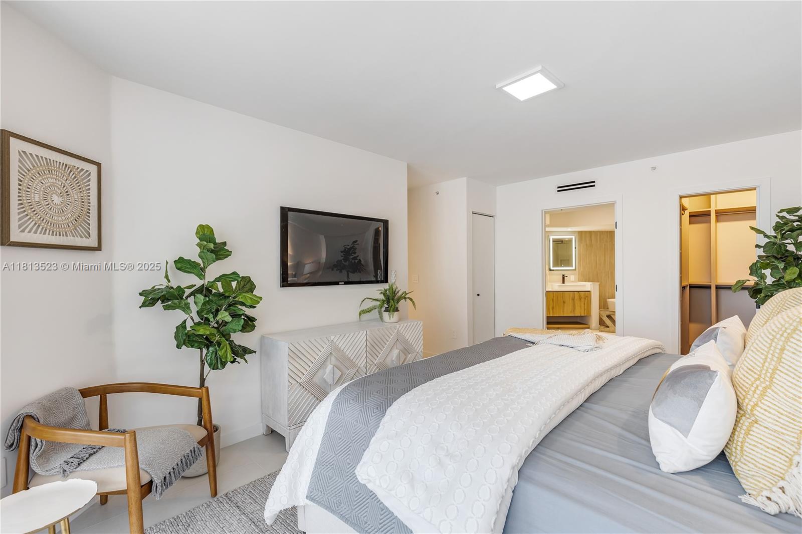 6301 Collins Avenue, Unit 1405 Miami Beach, FL 33141 - Photo 16 of 34 a bedroom with a bed and a potted plant