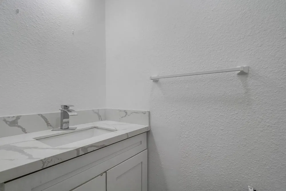 734-738 Grand Avenue Spring Valley, CA 91977 - Photo 19 of 30 a bathroom with a granite countertop sink and white cabinets