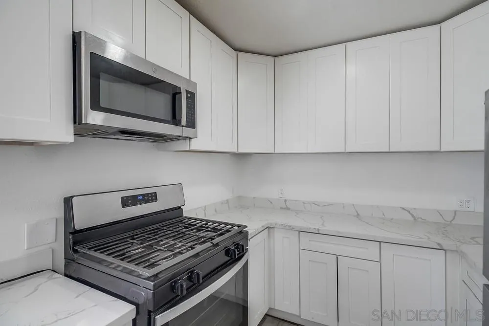 734-738 Grand Avenue Spring Valley, CA 91977 - Photo 22 of 30 a kitchen with white cabinets and a stove top oven