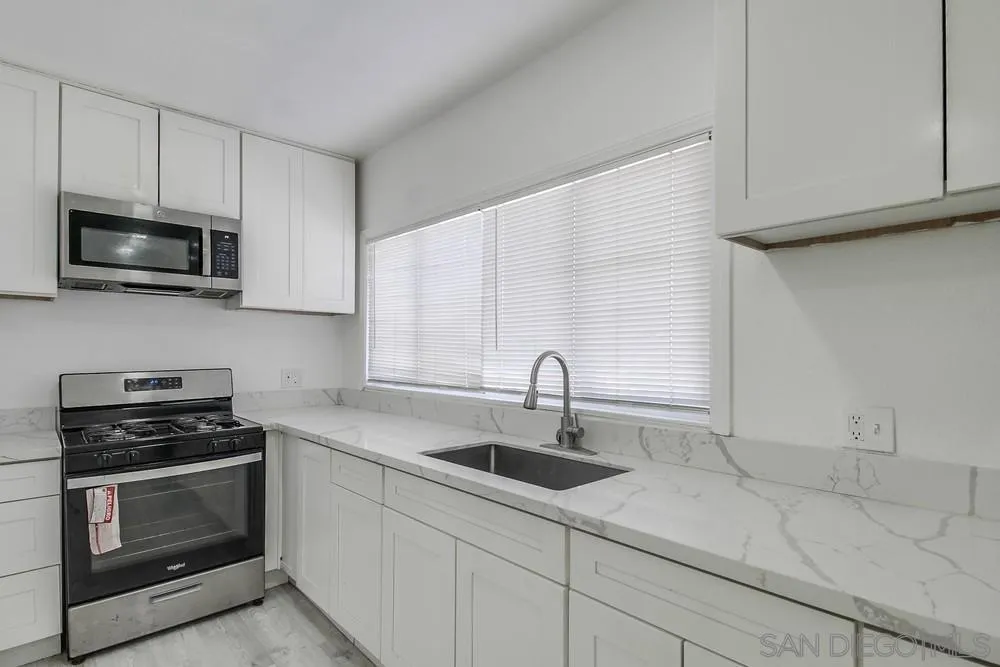 734-738 Grand Avenue Spring Valley, CA 91977 - Photo 25 of 30 a kitchen with stainless steel appliances a stove a microwave a sink and cabinets
