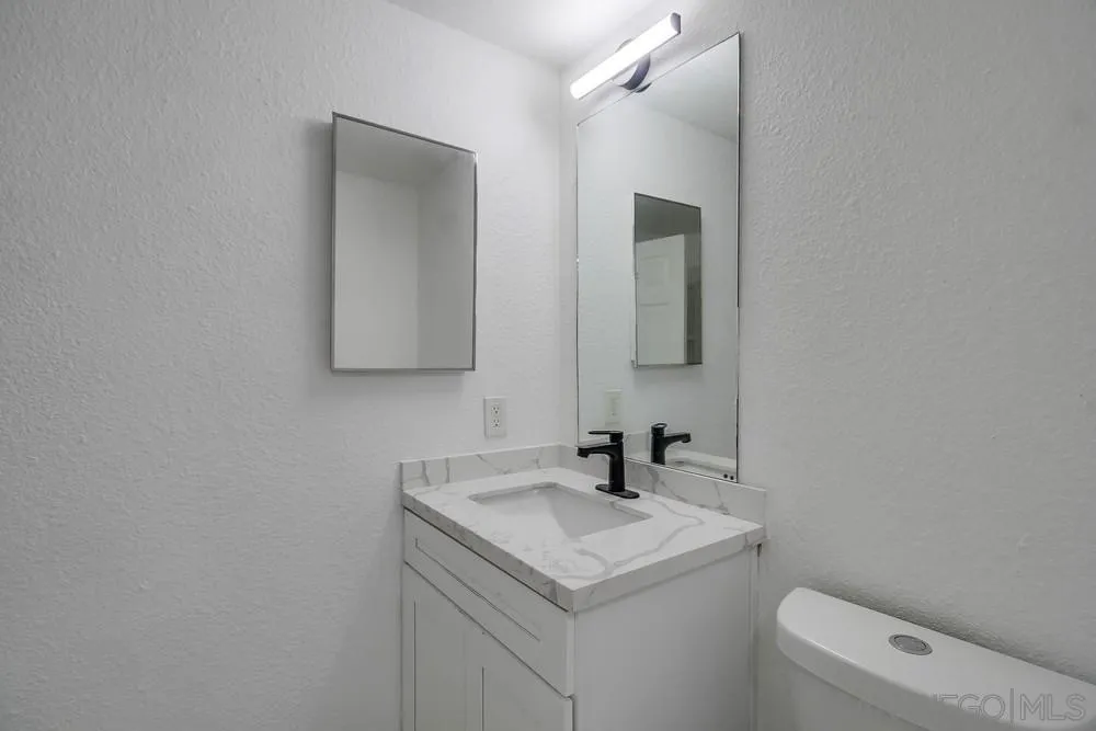 734-738 Grand Avenue Spring Valley, CA 91977 - Photo 28 of 30 a bathroom with a toilet sink and mirror